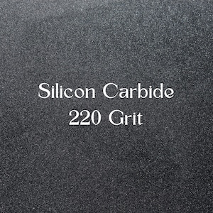 Könnte beinhalten: Nahaufnahme einer dunkelgrauen, strukturierten Oberfläche. Weißer Text lautet "Silicon Carbide" über "220 Grit". Die Oberfläche scheint ein feines Schleifmaterial zu sein.