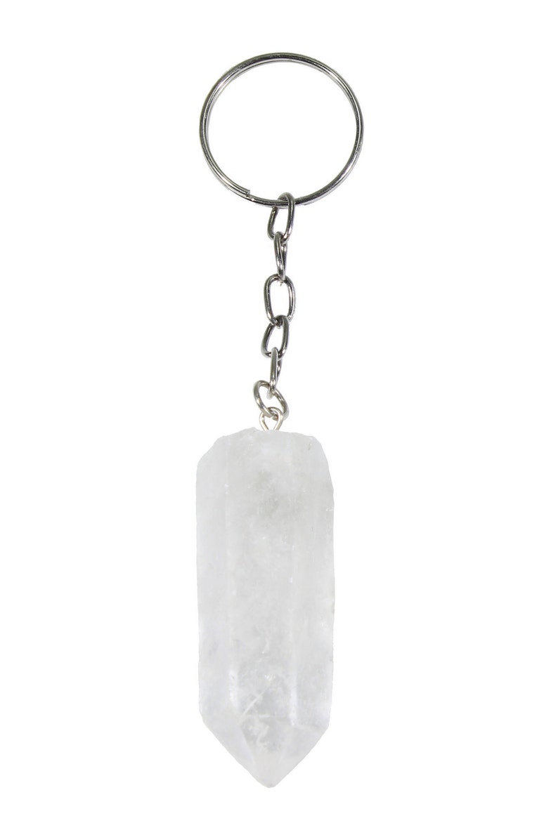 May include: A clear quartz crystal keychain with a silver-colored chain and key ring. The crystal is a rectangular shape with a pointed end. The keychain is against a white background.