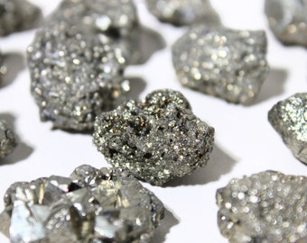 May include: A collection of small, rough, silver-colored pyrite crystals. The crystals have a sparkly, metallic appearance.