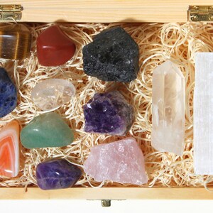 May include: A wooden box filled with a variety of crystals and stones, including amethyst, rose quartz, clear quartz, tiger's eye, and selenite.