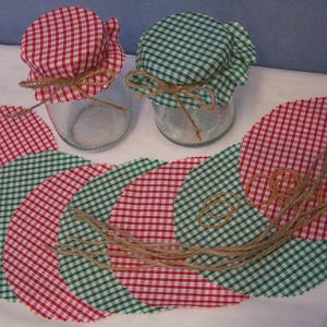 May include: A set of six fabric jar lids in red and green gingham patterns. The lids are tied with twine and are perfect for adding a touch of farmhouse charm to your kitchen.