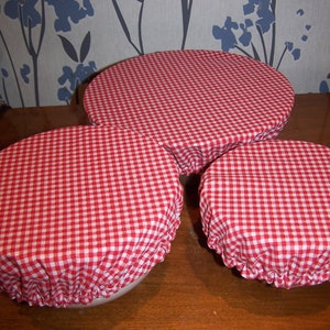 Peut inclure: Trois couvercles de bol en tissu gingham rouge et blanc de différentes tailles. Les couvercles sont faits d'un tissu de coton doux et sont parfaits pour garder les aliments frais.