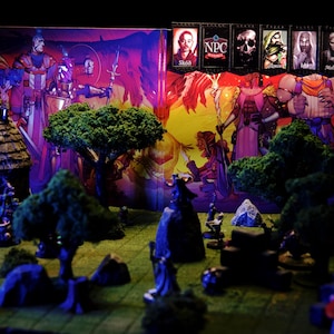 Puede incluir: Una escena de juego de rol de mesa con figuras en miniatura, &aacute;rboles y un tel&oacute;n de fondo con personajes de fantas&iacute;a. El tel&oacute;n de fondo incluye pancartas con retratos de personajes y el texto "NPC". La escena est&aacute; iluminada con luz p&uacute;rpura y amarilla.