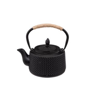 Op de afbeelding: Een zwarte gietijzeren theepot met een textuur van noppen op het lichaam en het deksel. De theepot heeft een gebogen tuit en een zwart metalen handvat dat aan de bovenkant is omwikkeld met lichtbruin jutekoord, met een kleine puntige knop.