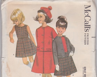 以下が含まれることがあります： ヴィンテージMcCall'sパターン6956、女の子用ドレス、スカート、ジャケット。イラストには、赤いコートドレス、チェック柄のスカートが付いたグレーのジャケット、チェック柄のドレスなど、3人の女の子の衣装が描かれています。パターンサイズは4です。