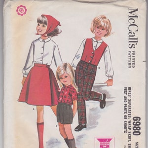 May include: Vintage McCall's sewing pattern for girls' separates, including a wrap skirt, shirt, vest, pants, and shorts. The illustration shows three children wearing the garments. The pattern is size 4.