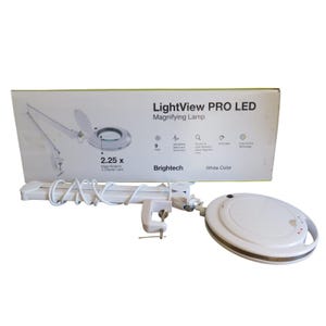 May include: A white LightView PRO LED magnifying lamp with an adjustable swing arm and a clamp base. The packaging box displays the product name, 2.25x magnification, 5 diopter lens, 9 watt power, and features like dimmable light and color tuning.