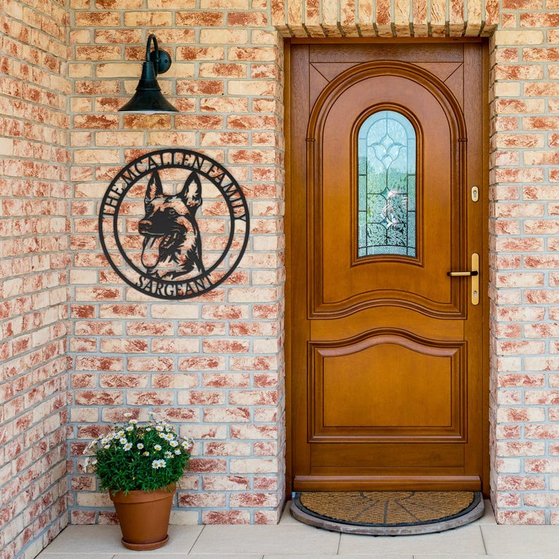 May include: A circular black metal wall sign featuring a silhouette of a German Shepherd dog in the center. The text THE MCALLEN FAMILY is arched along the top edge, and the word SARGEANT is printed along the bottom edge of the circular frame.