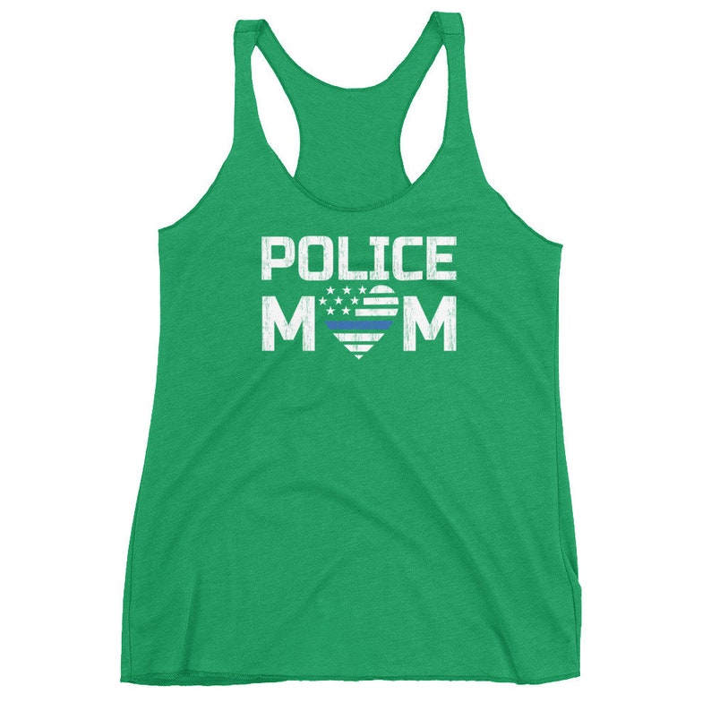 May include: A bright green racerback tank top featuring the white text POLICE MOM printed on the front. The letter O in MOM is replaced by a heart graphic containing white stars and stripes with a single horizontal blue line across the center.