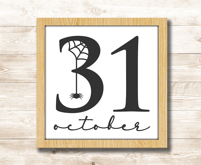 Puede incluir: Una impresi&oacute;n enmarcada con texto negro que dice "31 de octubre" con un dise&ntilde;o de ara&ntilde;a y telara&ntilde;a incorporado en el n&uacute;mero 3.