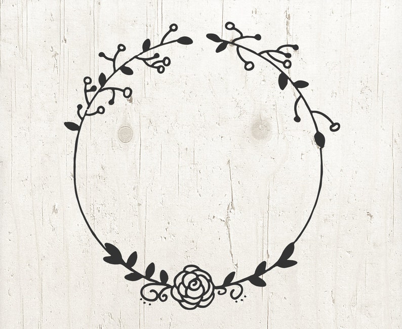 May include: A black and white floral wreath with a single rose at the bottom. The wreath is drawn in a simple, hand-drawn style.