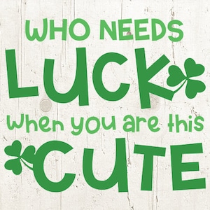 May include: Green text on a white wood background reads "Who needs luck when you are this cute" with a shamrock graphic next to the word "luck" and another shamrock graphic next to the word "cute".