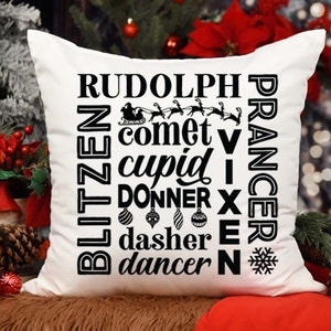 May include: White throw pillow with black text that reads "Rudolph, Blitzen, Prancer, Comet, Cupid, Donner, Dasher, Dancer, Vixen,  and  IX" with a snowflake and a small image of Santa's sleigh.