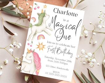 Pode incluir: Um cartão de convite branco com ilustrações de unicórnios, arco-íris e estrelas. O texto diz "Charlotte is a Magical One" e anuncia uma festa de primeiro aniversário. Inclui data, hora e informações de RSVP.