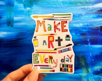 May include: A white sticker with colorful letters and illustrations of art supplies that reads "Make Art Everyday".