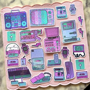 May include: A collection of holographic stickers featuring 1980s technology including a boombox, television, video camera, record player, computer, cassette tapes, floppy disks, a brick cell phone, and a corded telephone, all in shades of purple and teal.