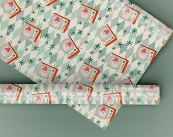 May include: A roll of wrapping paper with a pattern of vintage televisions with Santa Claus's face on the screen. The televisions are on a white background with a green and white diamond pattern.