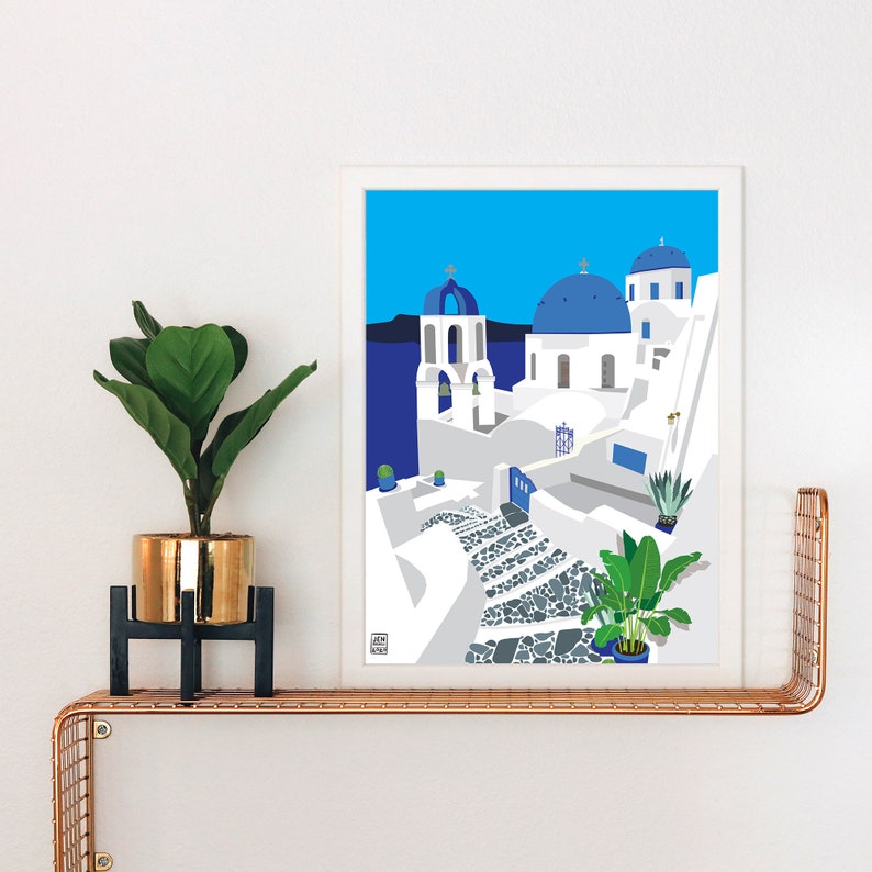Puede incluir: Una impresi&oacute;n enmarcada en blanco de una ilustraci&oacute;n azul y blanca de un pueblo griego con una iglesia con c&uacute;pula azul y un camino de piedra sinuoso.