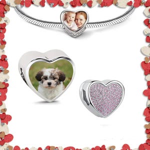 May include: Three silver heart-shaped charms. One charm features a photo of a dog, another charm features a photo of a mother and child, and the third charm is covered in pink glitter.