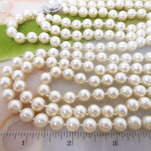 May include: A multi-strand pearl necklace with a silver clasp. The necklace is approximately 4 inches long.