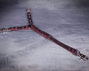 May include: A black leather dog leash splitter with red stitching and accents. The Y-shaped leash features silver-colored metal swivel clips at each end and a central attachment point. The leash is designed for dual dog walking.