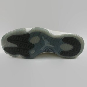 May include: White leather sneakers with a black rubber outsole. The outsole has a unique tread pattern.