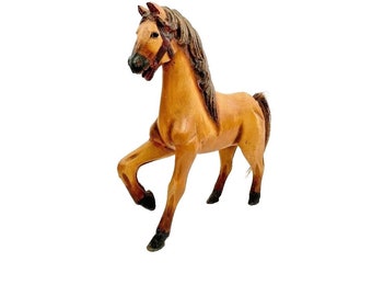 May include: A wooden horse figurine with a brown body and a dark brown mane and tail. The horse is standing on all four legs and has a bridle.