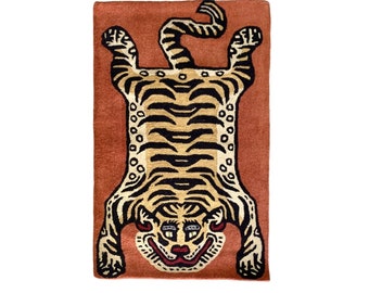 May include: A brown and orange tiger rug with black stripes. The tiger is lying on its back with its paws in the air. The rug has a red background.