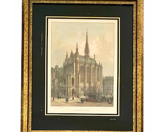 Puede incluir: Impresión enmarcada de una catedral con una alta aguja, en un marco dorado y ornamentado. La impresión representa una representación arquitectónica detallada del edificio, con figuras y carruajes en primer plano. El texto "LA SAINTE CHAPELLE" está en la parte inferior.