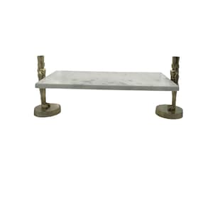 May include: A rectangular marble serving tray with a gray and white pattern. The tray is supported by two decorative metal figures on each end. The figures are in a standing pose and are attached to a circular base.