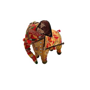 May include: A decorative elephant figurine crafted from fabric featuring a vibrant patchwork of red and yellow textiles. The surface is adorned with small circular mirrors, intricate embroidery, and small pom-pom accents on the ears and body.