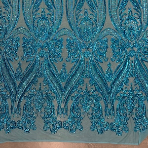 Puede incluir: Tela de lentejuelas azul turquesa con un patr&oacute;n de damasco. Las lentejuelas son iridiscentes y tienen un acabado brillante.