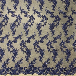 May include: Navy blue floral lace fabric with a delicate pattern of flowers and leaves. The lace is embellished with small sequins, adding a touch of sparkle.