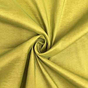 May include: A close-up of a smooth, green fabric with a subtle sheen. The fabric is folded and draped, showcasing its texture and drape.