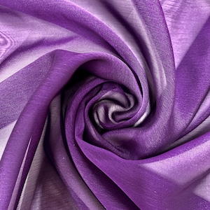 May include: Purple sheer fabric with a soft, flowing texture. The fabric is draped and folded to create a swirling pattern.