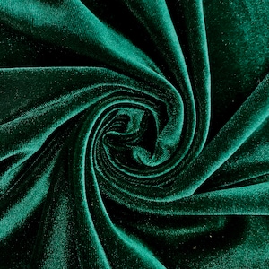 Puede incluir: Primer plano de una tela de terciopelo verde oscuro, que muestra la textura y los pliegues del material.