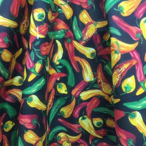 May include: Black fabric with a repeating pattern of red, yellow, and green chili peppers.