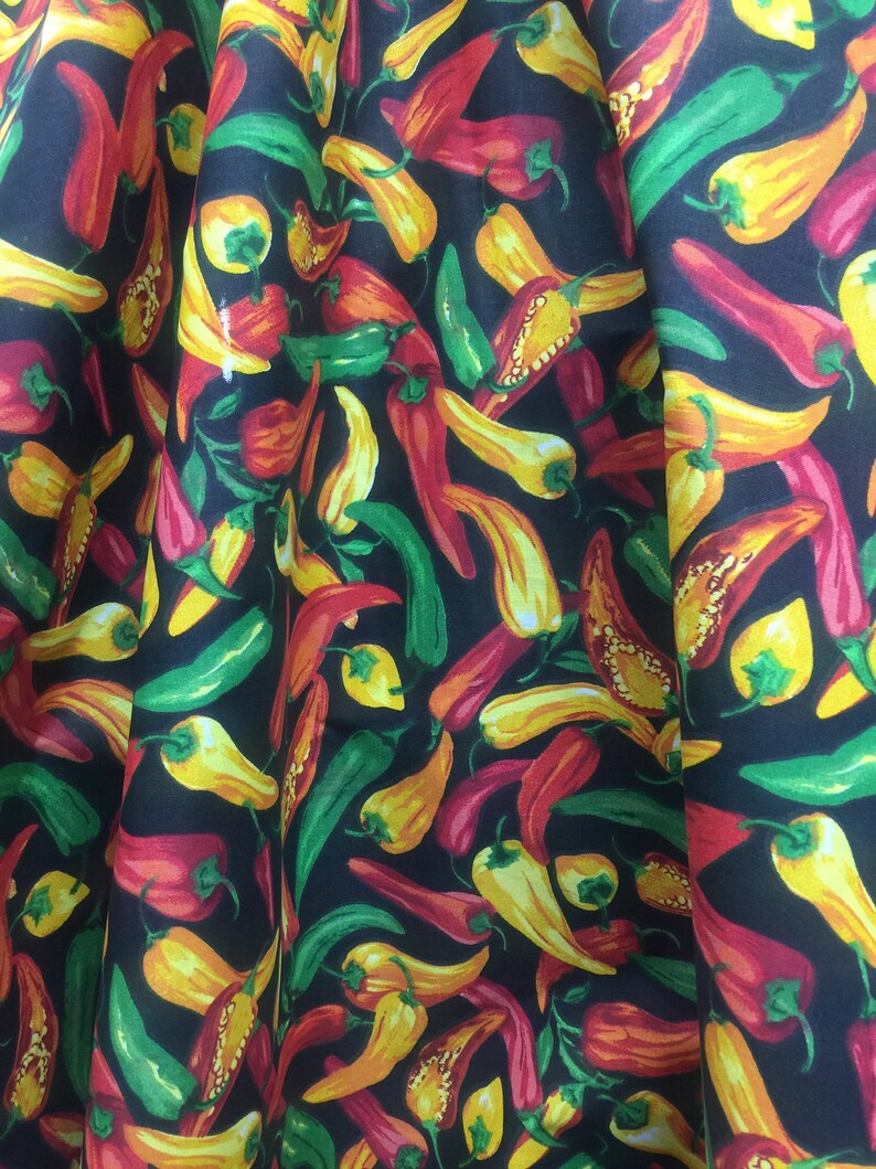 May include: Black fabric with a repeating pattern of red, yellow, and green chili peppers.