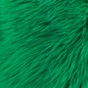 May include: Close-up of a bright green faux fur fabric. The fur is soft and fluffy, with a slightly textured surface.