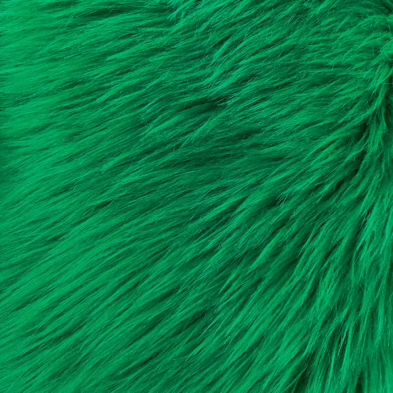 May include: Close-up of a bright green faux fur fabric. The fur is soft and fluffy, with a slightly textured surface.