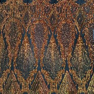 Könnte beinhalten: Gold- und kupferfarbener Paillettenstoff mit geometrischem Muster auf schwarzem Netzstoff.