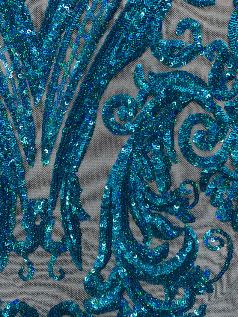 Puede incluir: Tela de lentejuelas azul turquesa con un patr&oacute;n de espiral. Las lentejuelas son iridiscentes y crean un efecto brillante.