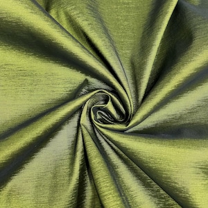 May include: A close-up of a green fabric with a subtle sheen. The fabric is wrinkled and folded, showing its texture.