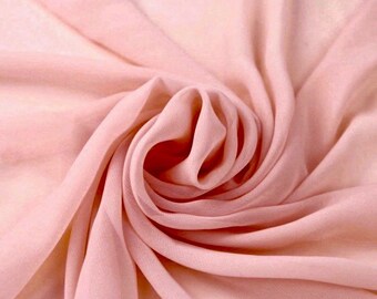 May include: A close-up of a soft, pink fabric with a smooth texture. The fabric is draped and folded, creating a swirling pattern.