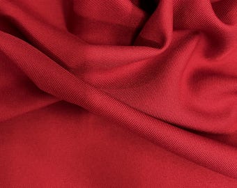 Puede incluir: Primer plano de una tela roja vibrante con textura acanalada. El material está drapeado, creando pliegues y sombras suaves. El color es un rojo intenso y sólido, adecuado para proyectos de indumentaria o decoración del hogar.
