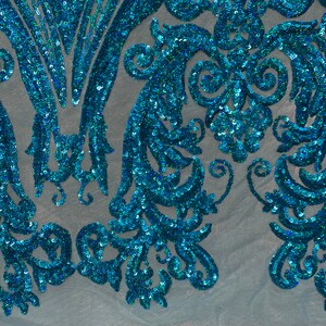 Puede incluir: Tela de lentejuelas azul turquesa con un patr&oacute;n floral sobre un fondo de malla azul claro.