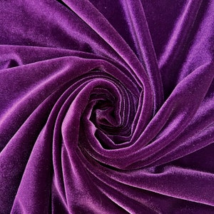 May include: A close-up of a deep purple velvet fabric, with a soft, plush texture. The fabric is draped and folded, creating a swirling pattern.