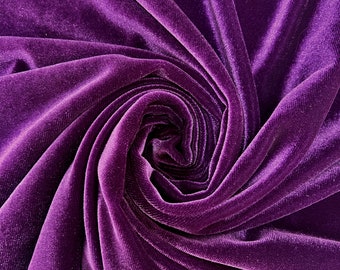 May include: A close-up of a deep purple velvet fabric, with a soft, plush texture. The fabric is draped and folded, creating a swirling pattern.