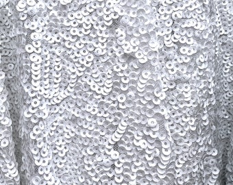 May include: White fabric with a close-up of a pattern of small, round, white sequins.