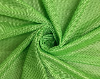May include: Close-up of a vibrant green fabric with a textured, grid-like pattern. The material is gathered and folded, creating a swirling effect. The bright, solid color suggests a lightweight textile suitable for various applications.